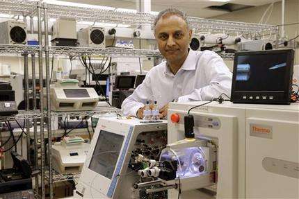 In this Aug. 10, 2015, photo, Dr. Akhilesh Pandey, a researcher at Johns Hopkins University, poses alongside a mass spectrometer in his laboratory in Baltimore. Pandey's research analyzes both adult and fetal tissue, and by identifying which proteins are present, he can get clues that could be used to help detect cancer in adults earlier. (AP Photo/Patrick Semansky)